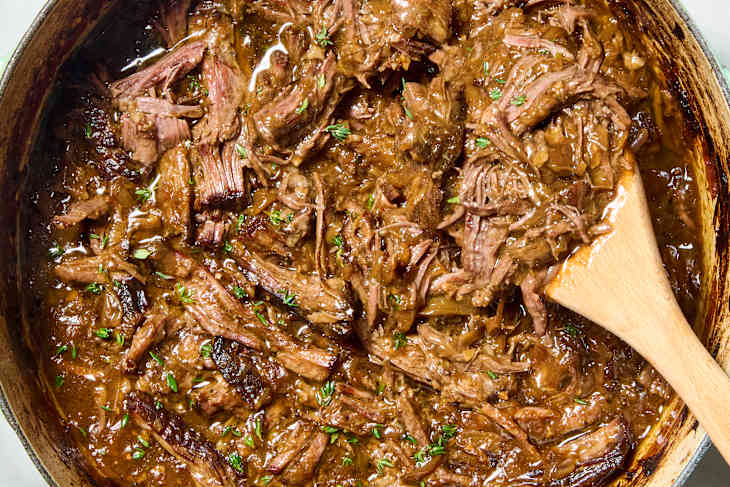 overhead shot of french onion pot roast in a pot over being shredded