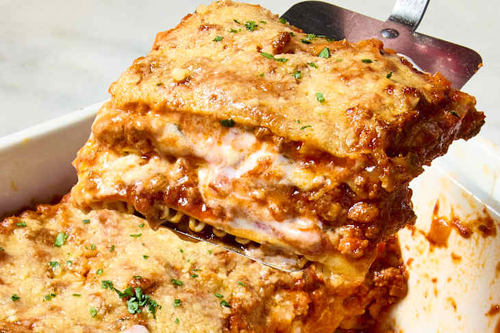 A slice of lasagna lifted on a spatula