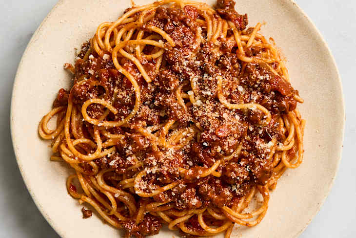 overhead shot of spaghetti bolognese on a beige plate