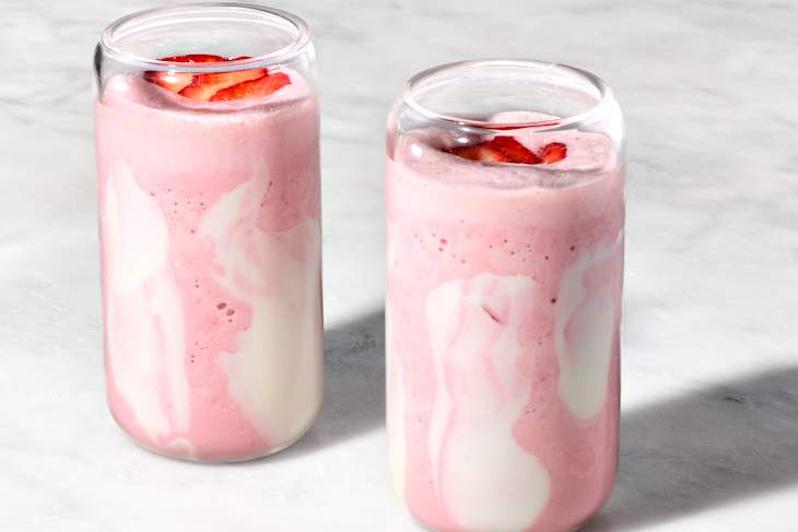 angled shot of two glasses full of a strawberry cloud smoothie