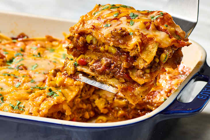 angled shot of a scoop being taken from the casserole dish