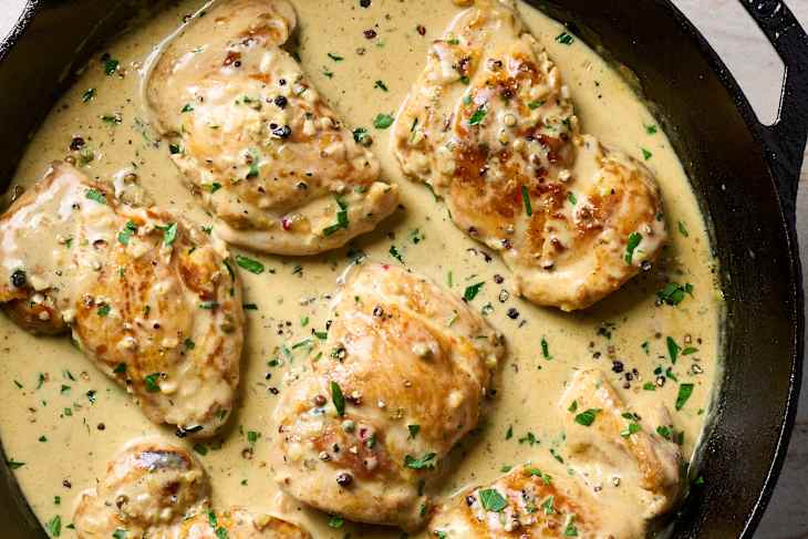 An overhead view of chicken au poivre in a cast iron skillet