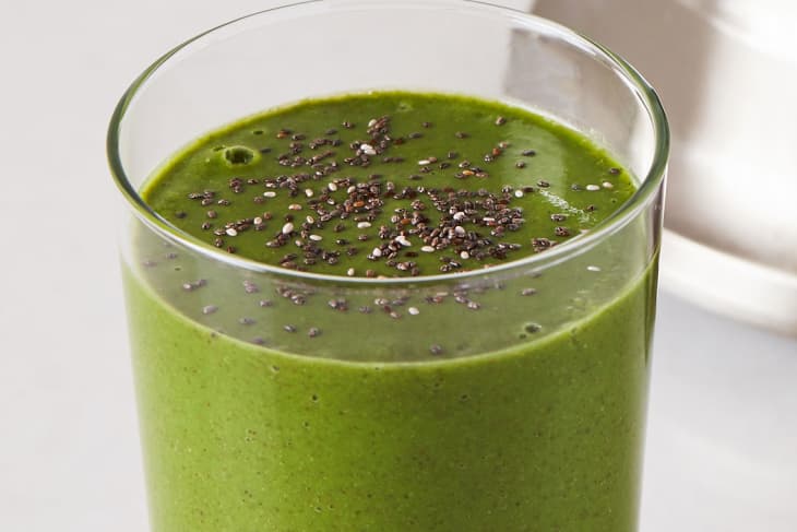 Pineapple kale green smoothie topped with chia seed in glass.