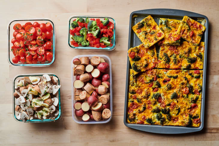 Power Hour sheet pan dinner ingredients prepped on countertop. Top left to right; tomatoes, broccoli and peppers, bottom left to right; mushrooms, sausage and potatoes, far right, frittata in sheet pan.