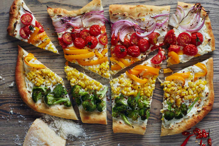 Rainbow pizza on a cutting board, cut into irregular slices