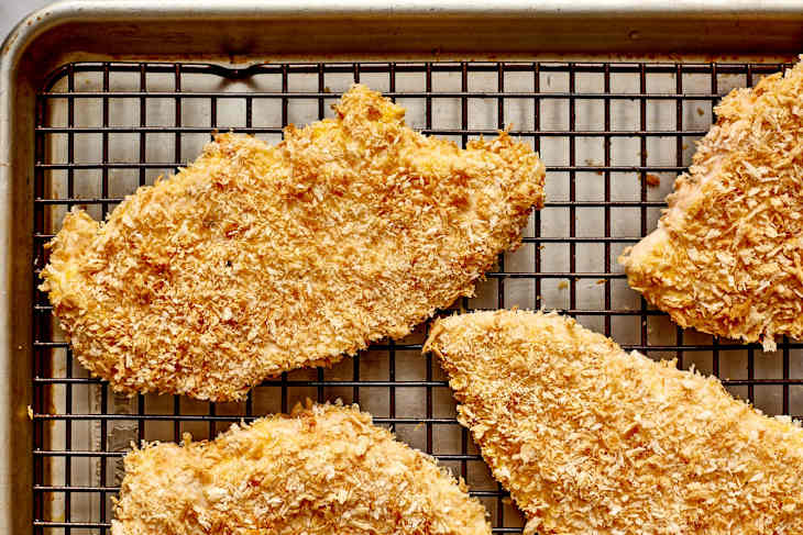 Crispy breaded chicken cutlets on a wire rack, showcasing a golden-brown coating.