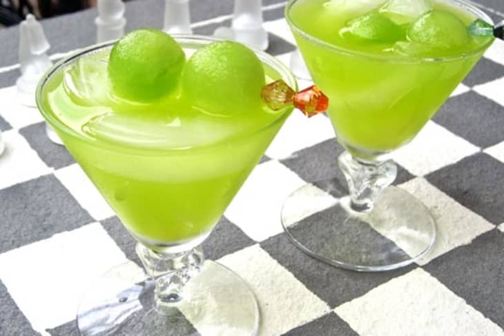 Melon ball in a cocktail glass, garnished with melon balls on a toothpick