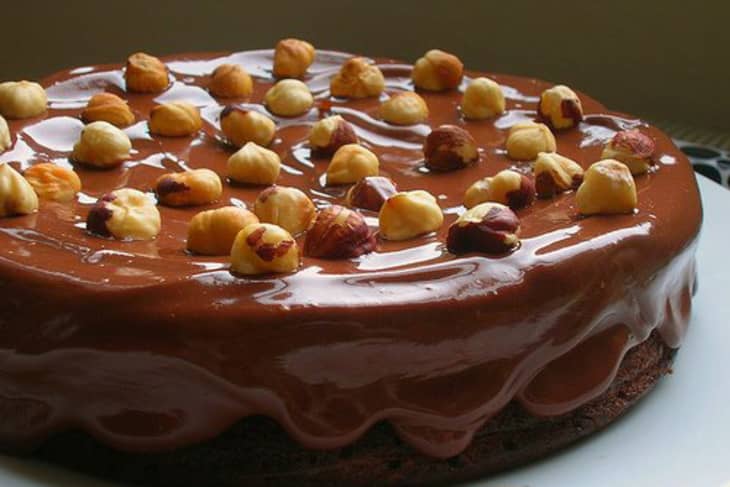 Nutella cake covered with ganache and studded with hazelnuts