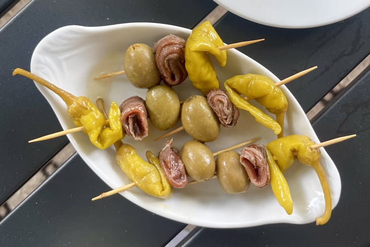 Overhead photo with serving dish with Spanish gildas on skewers made with pepperoncini, olives, anchovies