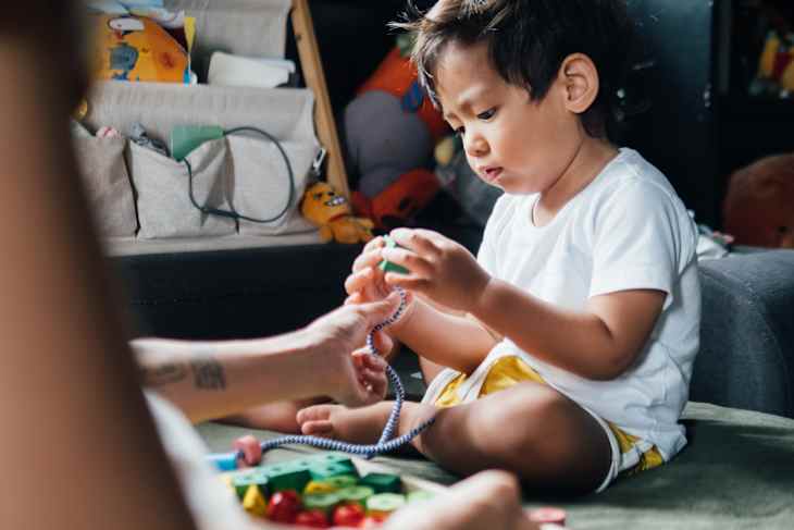 Asian little boy playing toy with his mother