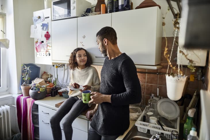 Father with daughter eating a piece of cake in kitchen at home