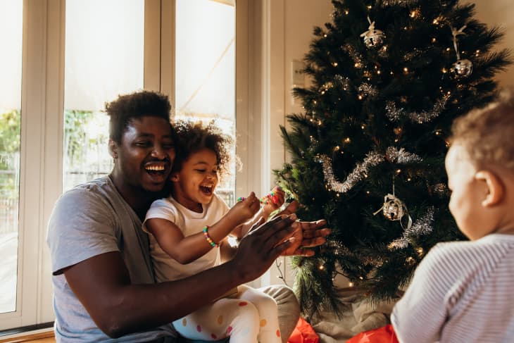 Young Australian father enjoying opening presents with his daughter early on Christmas morning