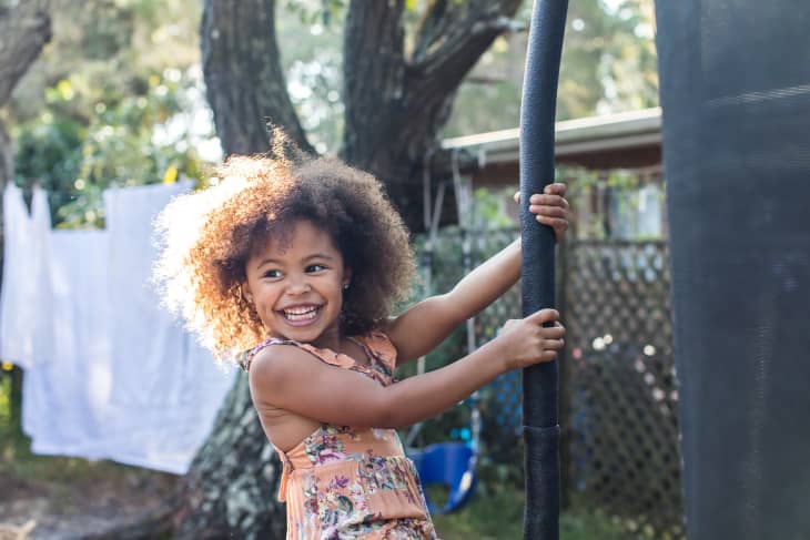 girl excitedly swings around her trampoline