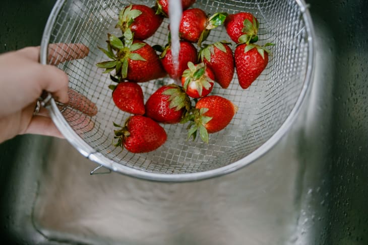 High angle view of rinsing strawberries in kitchen sink