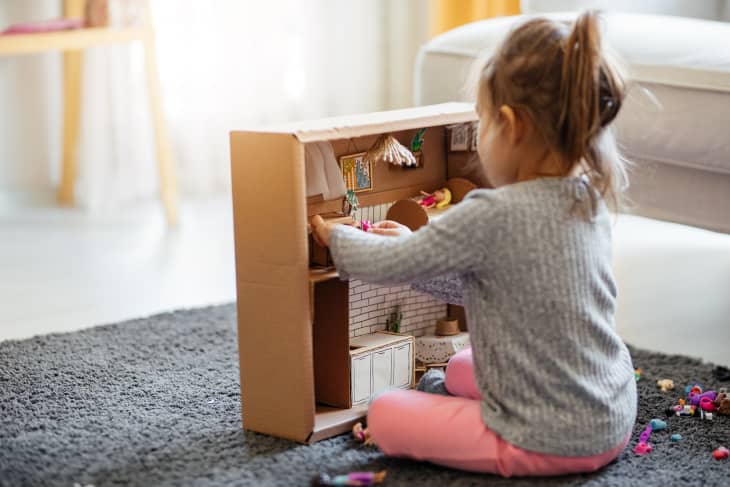 Shot of a little girl playing with her dollhouse at home