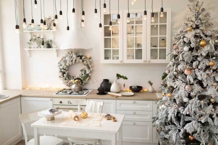 Interior white kitchen and light christmas decor. Preparing homemade cookies at kitchen. Festive kitchen in Christmas decorations. New Year and Christmas concept.