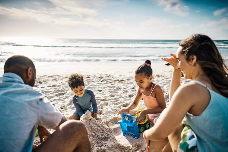 Young couple and their two kids spending the day at the beach