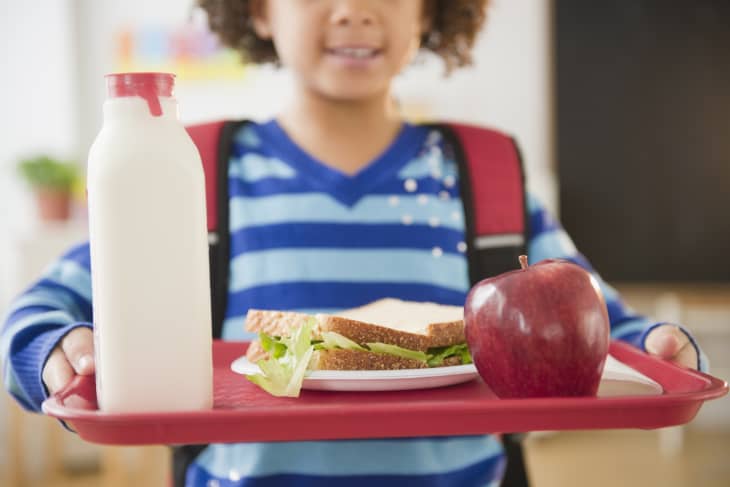 African American school girl holding lunch on a tray