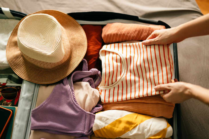 Woman Packing a Shirt in a Suitcase for a Summer Vacation