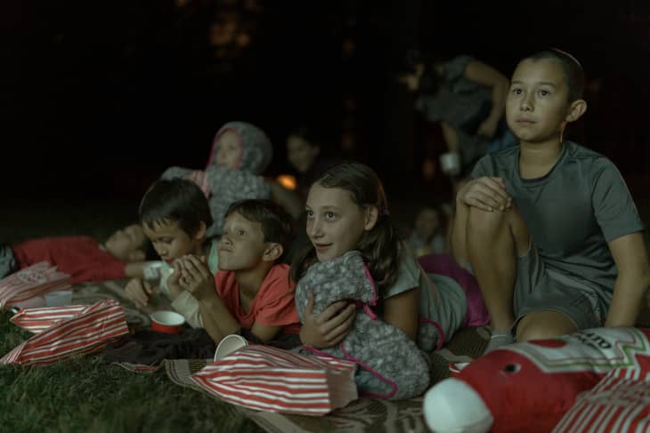 Kids watching movie on outdoors projector screen