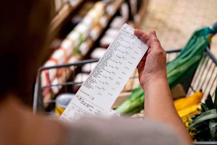 Woman looking at a receipt after shopping at the supermarket