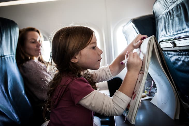 Girl (6yrs) on airplane, drawing on tablet