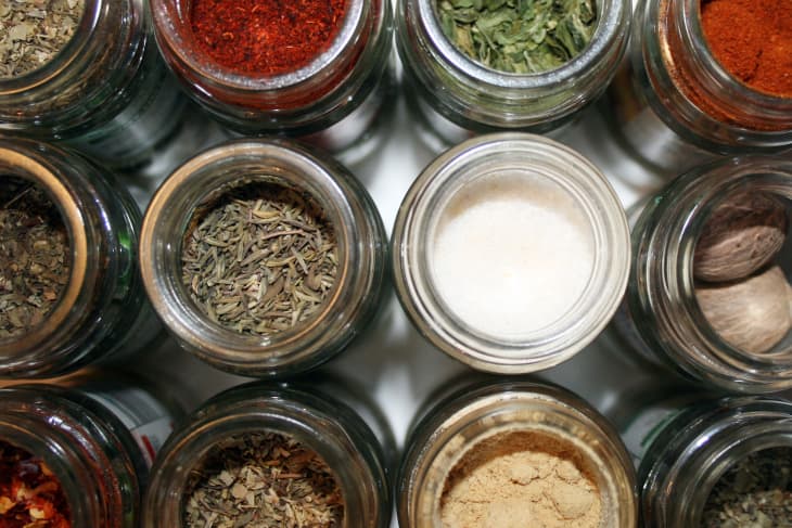 Aerial shot of open round, glass jars containing various herbs and spices