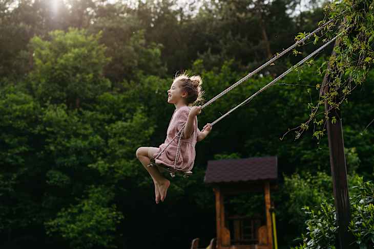 girl swinging on garden swing.
