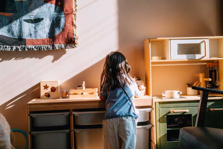 Girl playing with toy kitchen