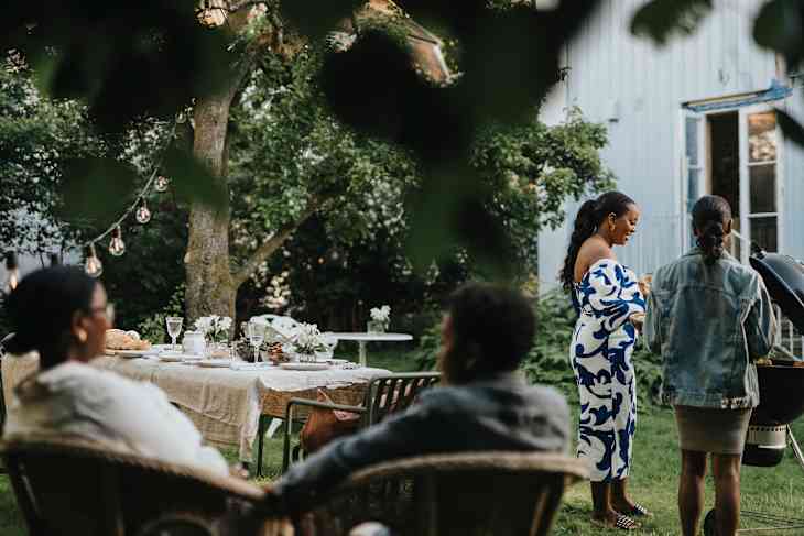 family members barbecuing during social gathering at garden party