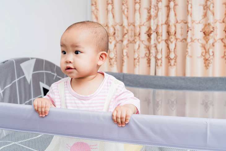 Baby playing in portable crib/pack 'n' play