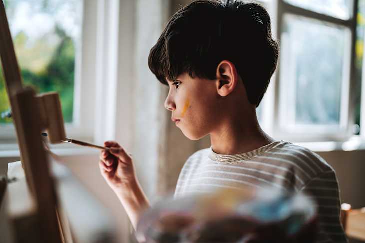 Boy painting during art class