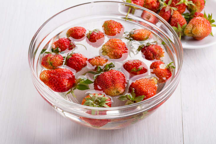 washed strawberries in water in a glass bowl
