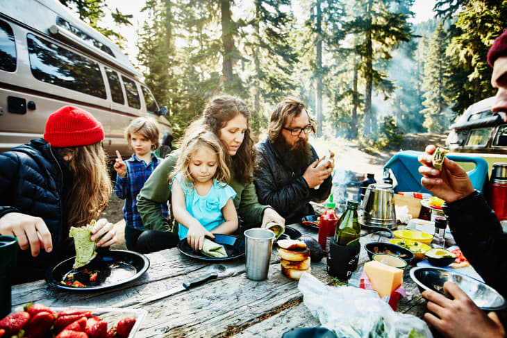 Family and friends eating breakfast while camping
