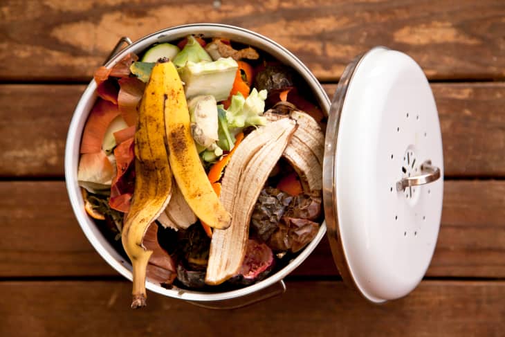 Overhead view of fruit and vegetable scraps in a white enamel container