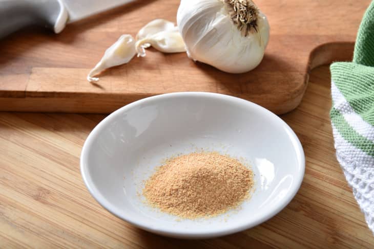 A spice dish of garlic powder with fresh garlic