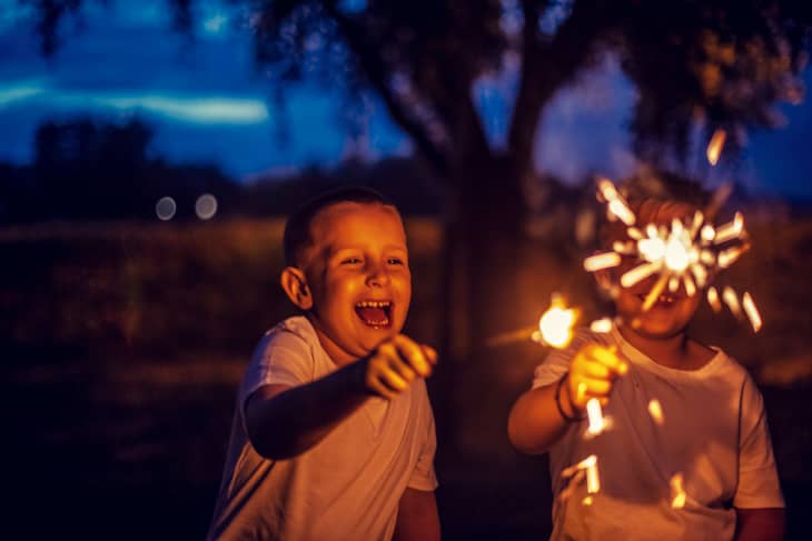 Boys have fun in the park with firework sparkles