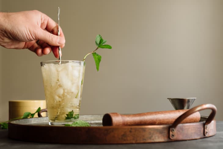 Male mixologist's hand mixing a cocktail in a glass