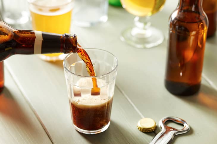 Pouring Dark Beer From Bottle In Glass