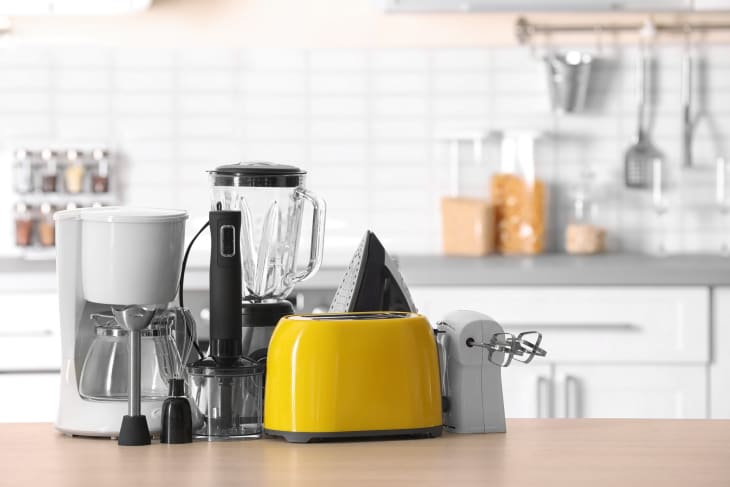 varied kitchen appliance on counter, blender, coffee maker, yellow toaster, hand mixer, emulsifier
