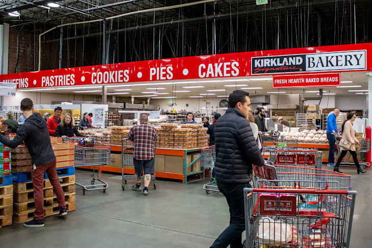 A view of customers roaming about selecting items from the bakery section at Costco.