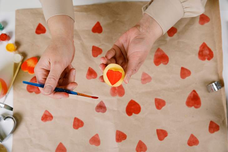 heart shaped potato stamp on craft paper. The process of decorating a gift for Valentine's Day. Getting ready for the celebration on February 14th.