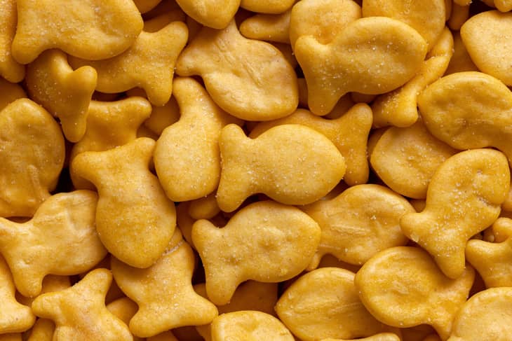 Goldfish cookies background. Closeup view of fish-shaped salted crackers. Small biscuits.