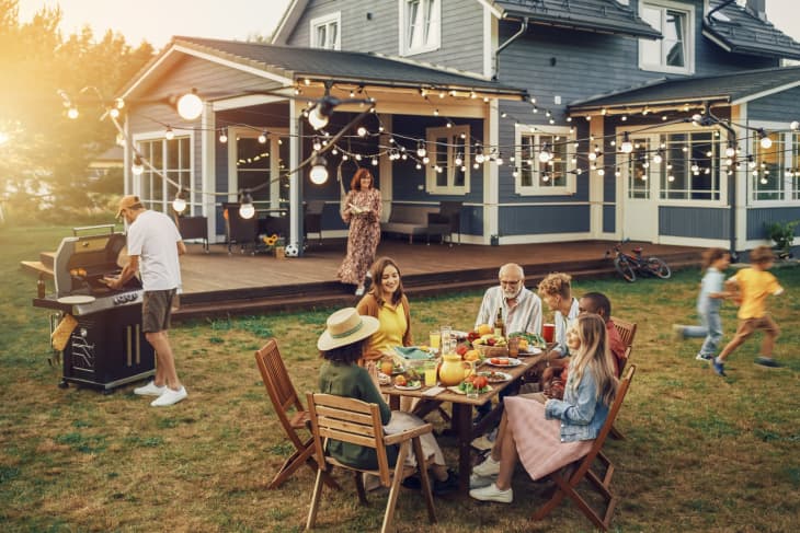 Big Family and Friends Celebrating Outside at Home. Diverse Group of Children, Adults and Old People Gathered at a Table, Having Fun Conversations. Preparing Barbecue and Eating Vegetables.