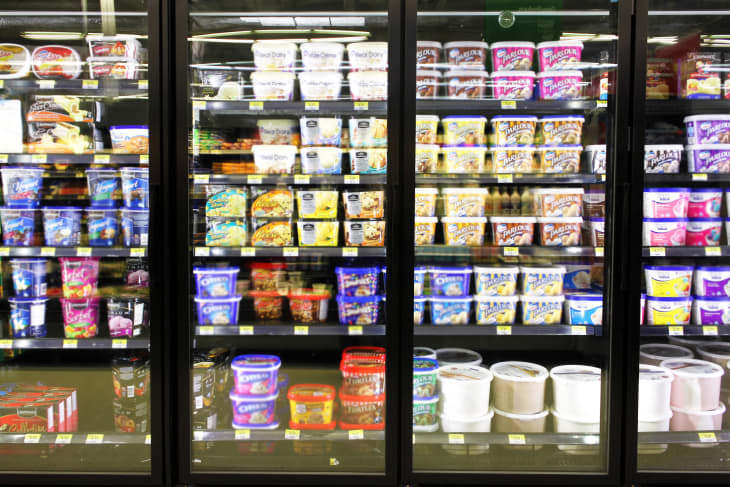 Different brands and flavors of ice cream on fridge shelves in a supermarket. Based on studies, half of the population in North America eat ice cream regularly.