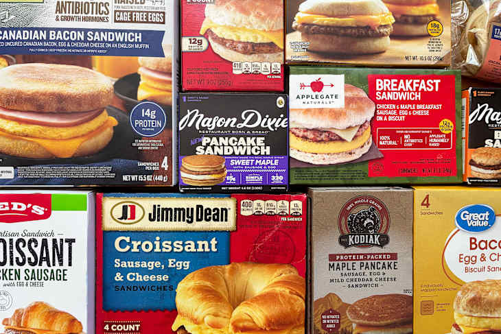 Assorted breakfast sandwich boxes featuring croissants, biscuits, and pancakes with various fillings like sausage, egg, and cheese.