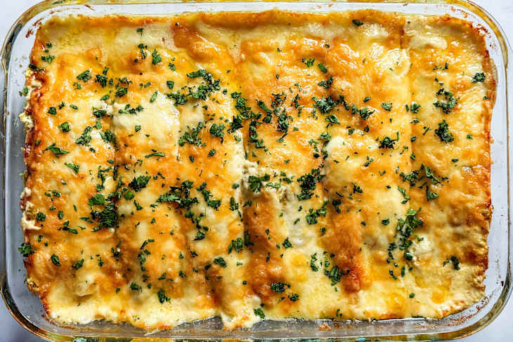 Chicken enchiladas in glass bakeware.