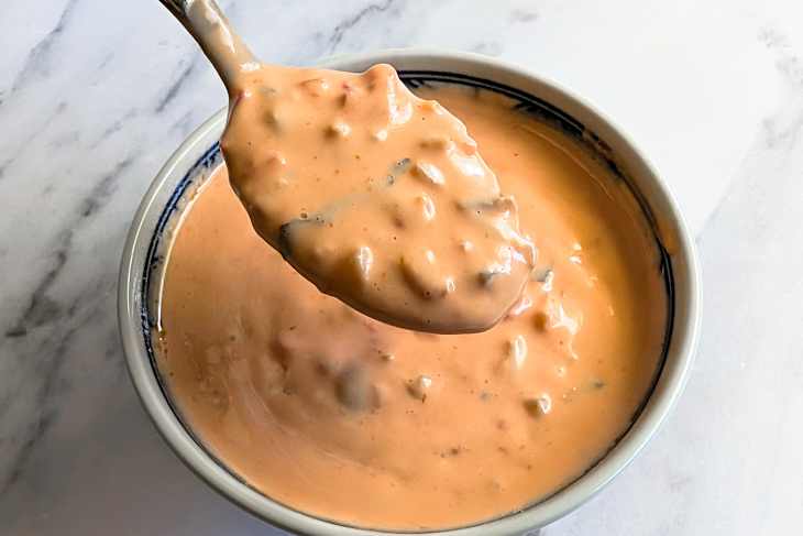 Bowl of Giardiniera sauce with some on spoon.