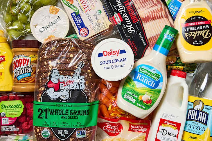 Assorted grocery items including bread, yogurt, sauces, bacon, and fresh produce.