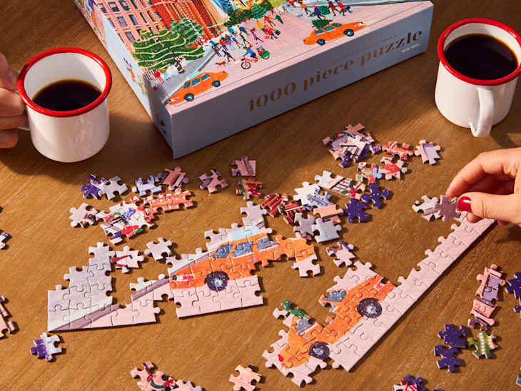 someone doing a puzzle with mugs
